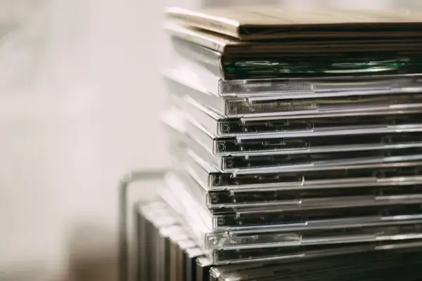 Stos przezroczystych pudełek z płytami CD, idealny do przechowywania nowości płytowych.