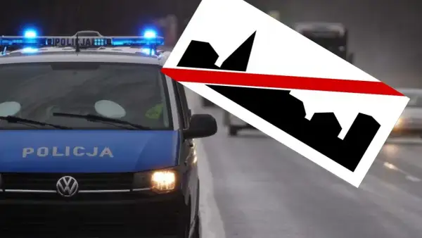 Policyjny radiowóz z włączonymi sygnałami świetlnymi, obok znak d43.