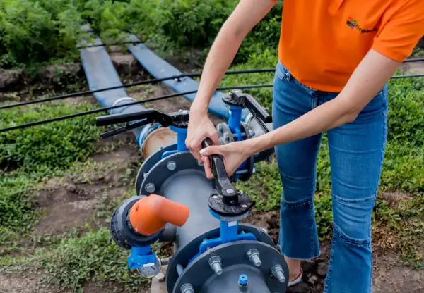 Montaż pompy głębinowej w studni kręgowej. Ręce dokręcają zawór przy systemie nawadniania.