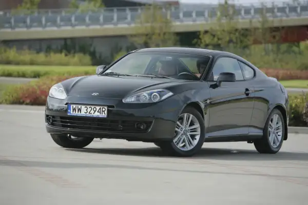 Ciemnoszary Hyundai Coupe 2.7 V6 z brązową tapicerką, zaparkowany na zewnątrz.