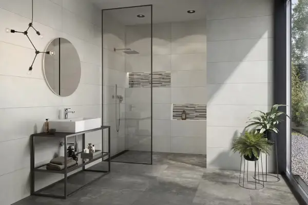 Modernes Bad mit Dusche, Waschbecken und Pflanzen. Die Wandfliesen mit Betonoptik verleihen dem Raum einen industriellen Touch.