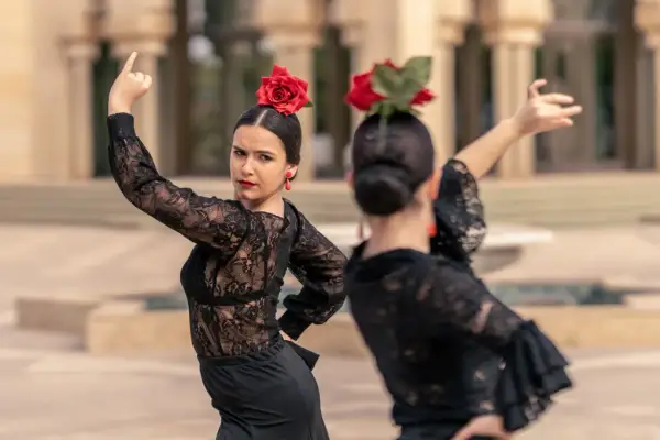 Una sevillana flamenca, con rosa roja en el pelo y pendientes a juego, baila con pasión.