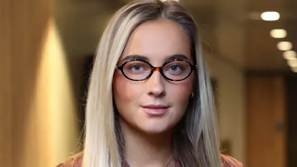 Evelina Andersson med glasögon och blont hår.