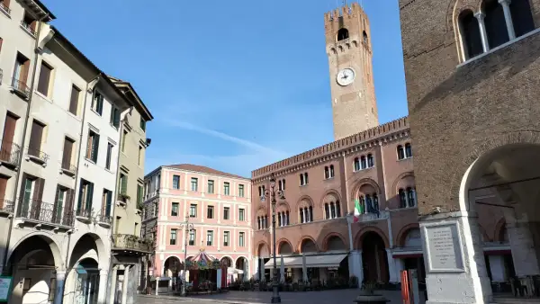 Rynek w Treviso, niedaleko Wenecji, z wieżą zegarową i karuzelą.
