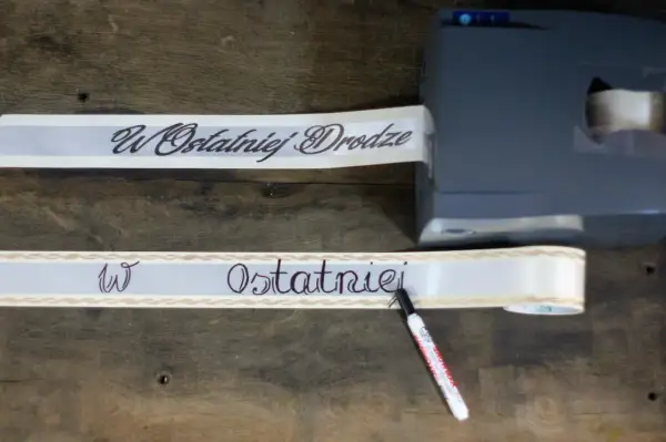 Szarfa pogrzebowa z napisem "W Ostatniej Drodze" jest drukowana i pisana ręcznie.