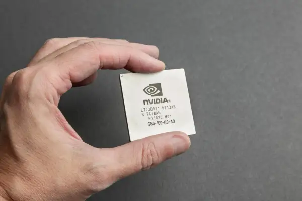 Dłoń trzyma procesor graficzny NVIDIA. Jeśli masz problemy z grafiką, dowiedz się, jak zresetować sterowniki karty graficznej.