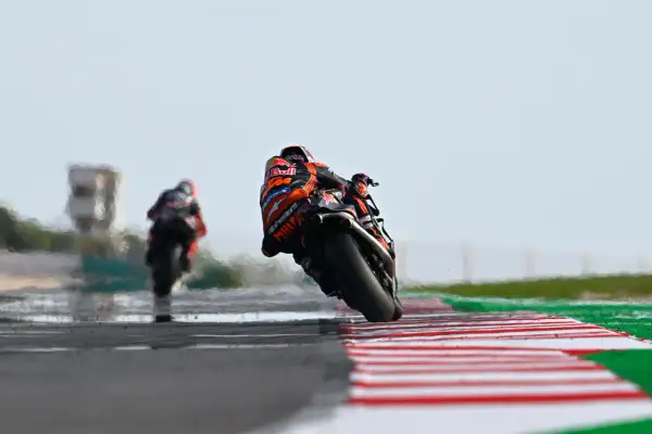 Piloto de MotoGP inclinado en curva, luchando por la pole position en el qualy.