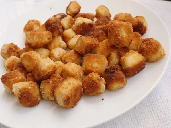 Krispiga, gyllene bitar av friterad tofu på en vit tallrik. Perfekt för ett snabbt och gott tofu recept.