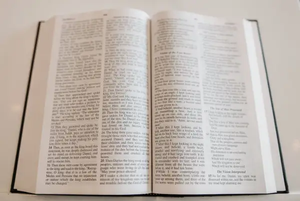 Otwarta Biblia, na jej stronach widnieje tekst, który może być fragmentem pieśni lub hymnu kościelnego.
