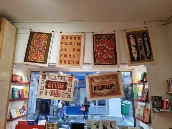 Affiches vintage avec un alphabet décoratif, des publicités de café, de laines et de théâtre.