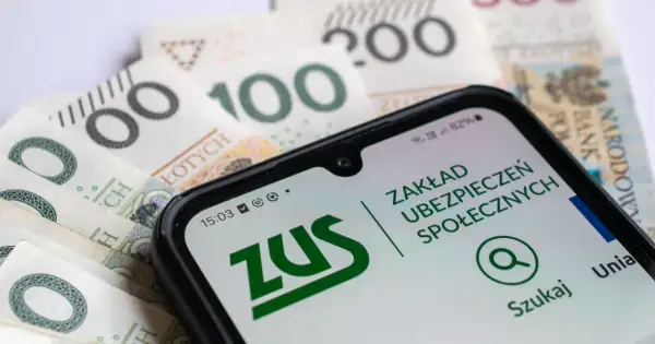 Telefon z aplikacją ZUS na tle polskich banknotów. Ubezpieczenie społeczne w zasięgu ręki.