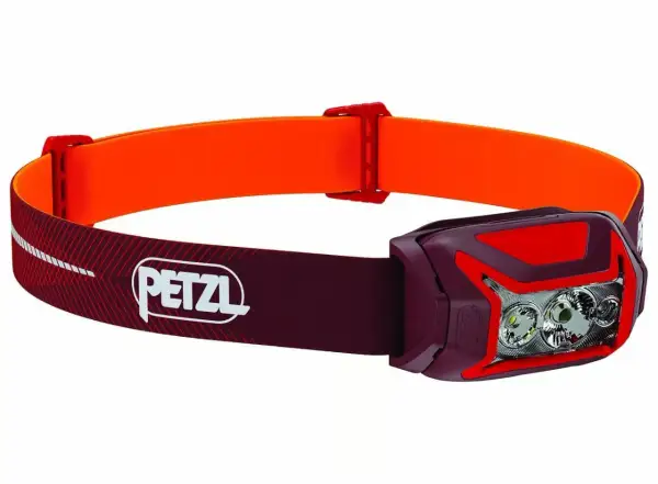Lampe frontale Petzl rouge et orange, idéale pour choisir votre éclairage d'aventure.