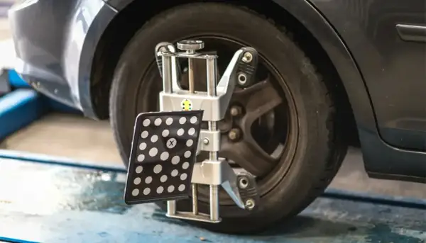 Appareil de mesure de géométrie de voiture fixé à une roue.