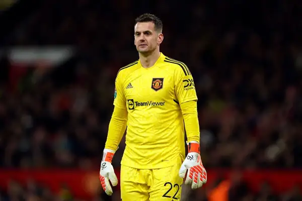 Tom Heaton, bramkarz Manchesteru United, w żółtym stroju bramkarskim, z rękawicami i numerem 22 na spodenkach.