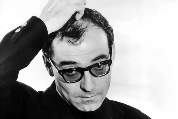 Jean-Luc Godard, en ikonisk filmskapare, med handen i håret. Hans filmer med Jean-Luc Godard är banbrytande.
