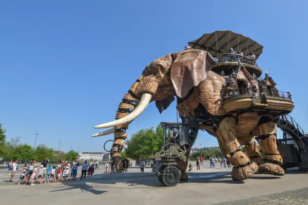 Le Grand Éléphant mécanique se promène sur l'île de Nantes, transportant des visiteurs émerveillés dans sa structure en bois.