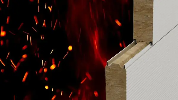 Przekrój izolacji budowlanej z wełny mineralnej, odpornej na ogień. Płonące iskry na czarnym tle podkreślają klasę reakcji na ogień.