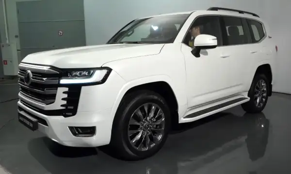 Biały Land Cruiser 300 z chromowanymi felgami i eleganckim grillem, gotowy na każdą przygodę.