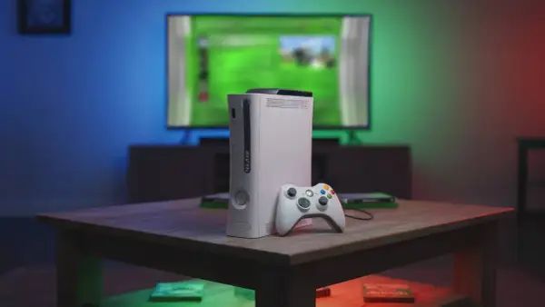 Biały Xbox 360 z kontrolerem na stoliku, przypominający czasy, kiedy wyszedł.