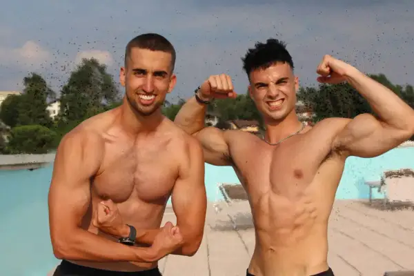 Due atleti muscolosi mostrano i loro addominali prima o dopo la corsa, con un sorriso e pose di forza.