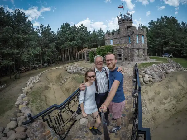 Rodzina pozuje do selfie przed kamiennym zamkiem, odkrywając nietypowe atrakcje Podlasia.