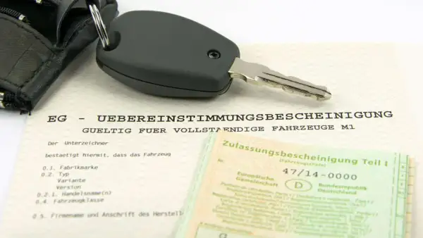 Clé de voiture sur un certificat de conformité européen. Ce document atteste de la conformité d'un véhicule, essentiel pour l'immatriculation, y compris pour les poids lourds.