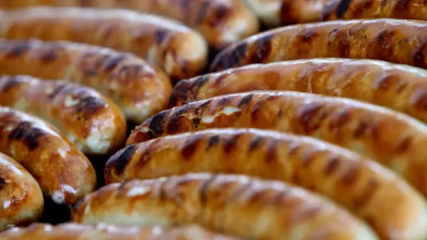 Reife Bratwürste auf dem Grill, die Frage "woher kommt die Bratwurst" wird hier kulinarisch beantwortet.