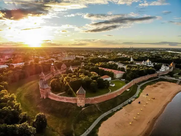 Solnedgång över Novgorod, en historisk stad med en imponerande kreml. Denna vy liknar en gammal **Novgorod karta** med sina befästningar och gyllene kupoler.