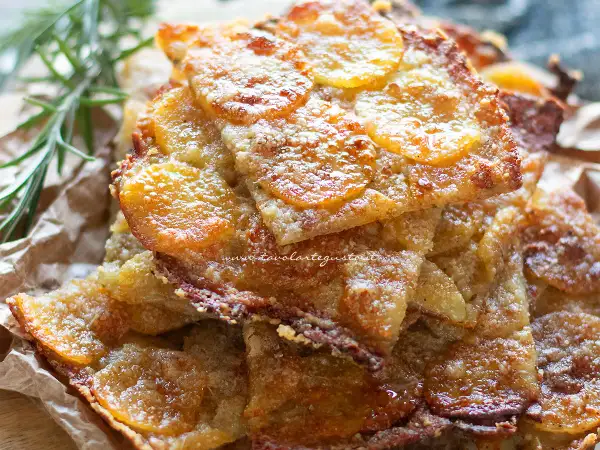Schiacciata di patate croccante, dorata e invitante, con fette sottili di patate e un tocco di rosmarino.