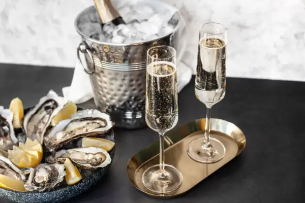 Austern mit Zitrone, Champagnergläser und Eis-Eimer mit Flasche.