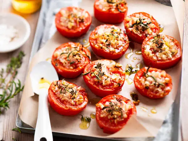 Tomates provençales garnies d'herbes et de fromage, rôties sur une plaque. Un délice parfumé !