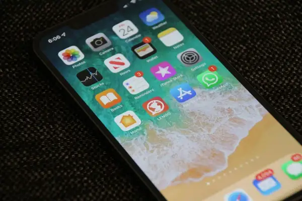 Ekran iPhone'a z ikonami aplikacji. Dowiedz się, jak zmniejszyć czułość ekranu dotykowego, aby uniknąć przypadkowych dotknięć.
