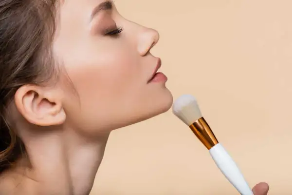 Primo piano del viso di una donna con pennello da trucco. La cipria traslucida dona un finish naturale e opacizzante, il suo significato è perfezione.