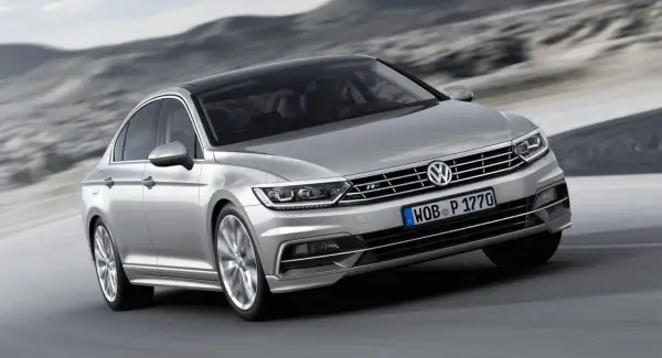 Silver Passat GTR glider fram på en väg med berg i bakgrunden.