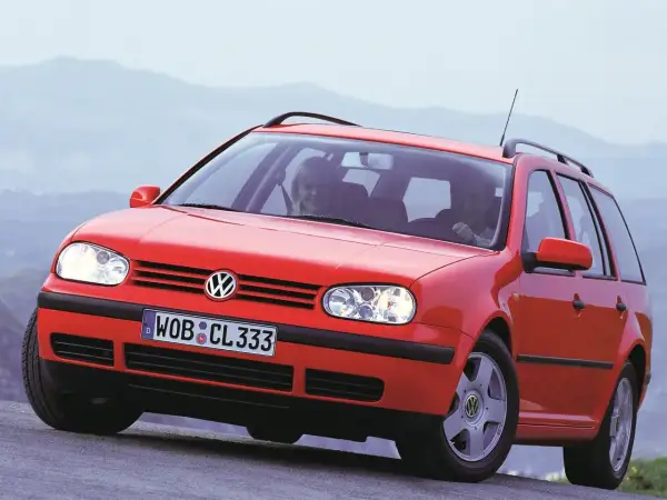 Czerwony Volkswagen Golf 4 Variant z uśmiechniętymi pasażerami. Widać przednie światła i grill, ale nie ma tu golf 4 żarówki tylne.