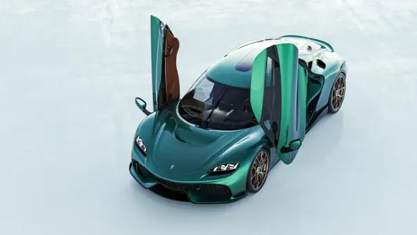 Zielony Koenigsegg Gemera z otwartymi drzwiami, gotowy do podróży.