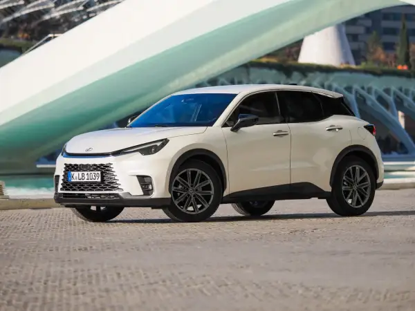 Biały Lexus LBX na tle nowoczesnej architektury. Sprawdź jego lexus lbx dane techniczne i odkryj możliwości tego miejskiego SUV-a.