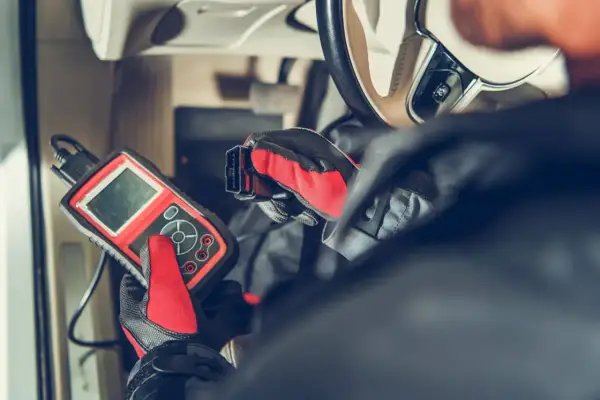 Mechanik diagnozuje problem z czujnikiem ABS w Astrze H, używając skanera diagnostycznego.