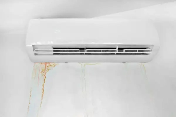 Condizionatore perde acqua nel muro, lasciando macchie di umidità e ruggine.