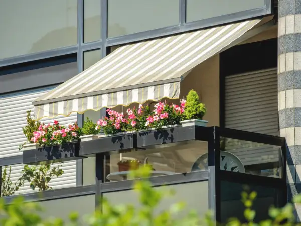 Jak zrobić daszek na balkon? Ten markiza z kwiatami to inspiracja.