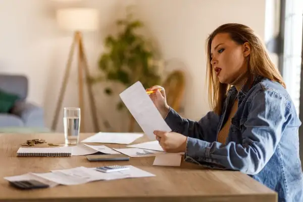 Donna analizza la sua busta paga di 22 giorni lavorativi, circondata da fogli e calcolatrice.