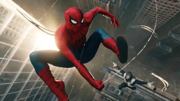 Spiderman w swoim ikonicznym stroju skacze między wieżowcami. Na dole inny przeciwnik w czarno-białym stroju.