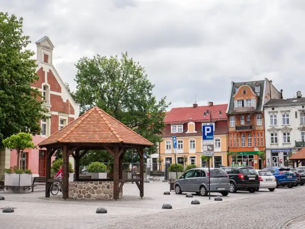 Rynek w Starogardzie Gdańskim, stolicy Kociewia, z drewnianą studnią i kolorowymi kamienicami.