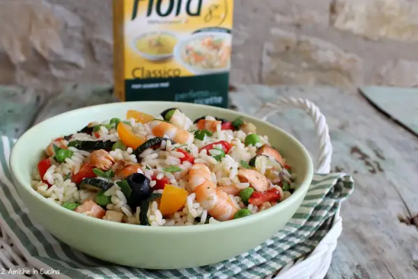 Un'appetitosa insalata di riso con pesce, gamberetti, verdure e olive, pronta per essere gustata.