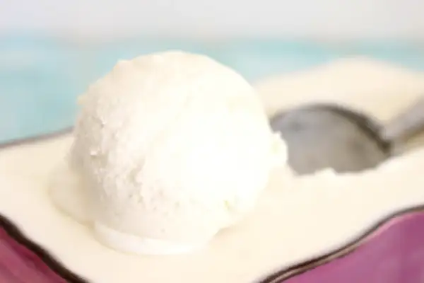 Una bola cremosa de helado de nata Thermomix sobre un plato, lista para ser disfrutada.