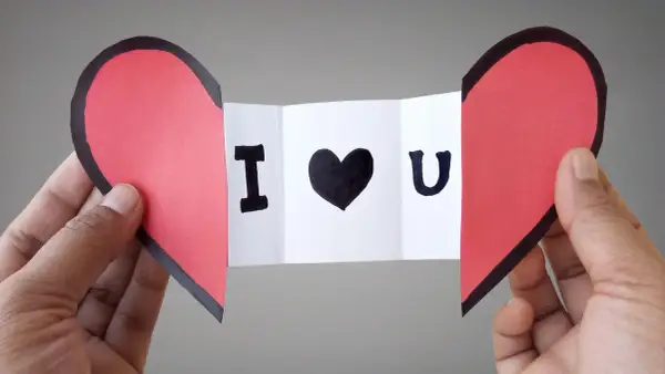 Cuore rosso diviso a metà, con un biglietto che dice "I ♥ U". Un'idea per i san valentino lavoretti fai da te.