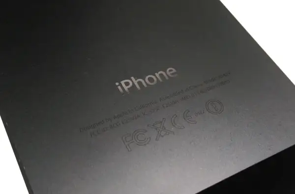 Tył iPhone'a z wygrawerowanym logo i informacjami, w tym numerem IMEI: 013408009192055.