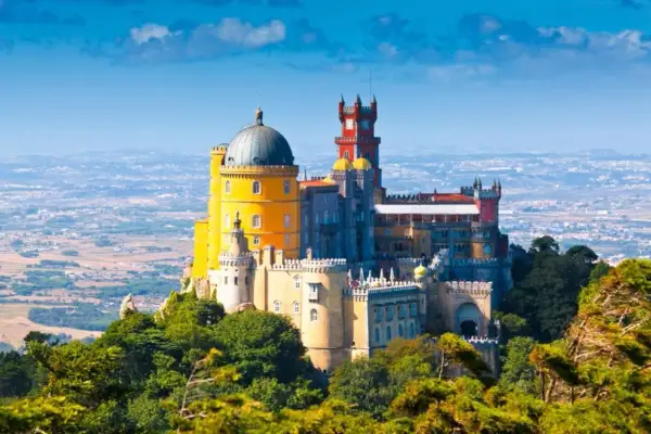 El Pazo da Pena, un palacio de cuento de hadas con cúpulas y torres coloridas, se alza majestuoso sobre una colina verde.