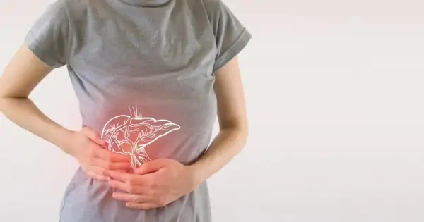 Osoba trzymająca się za brzuch, gdzie widoczny jest zarys wątroby. Może to symbolizować problemy trawienne lub skutki uboczne enzymów trawiennych.