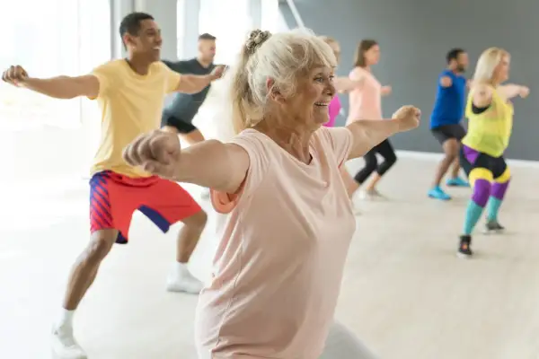Animation ehpad : des seniors actifs et souriants participent à un cours de danse dynamique, montrant que l'âge n'est pas une barrière à la joie de bouger.